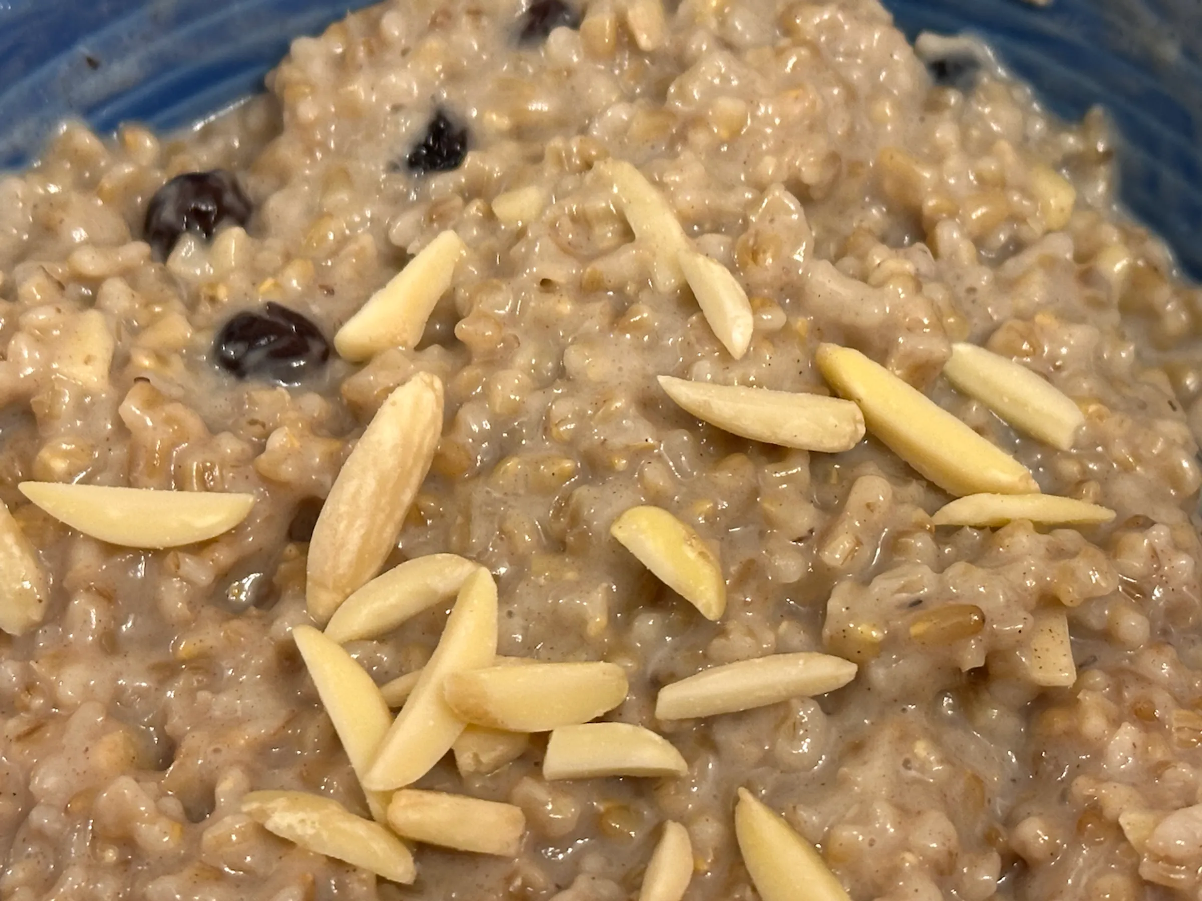 Oatmeal with blueberries and slivered almonds in a blue bowl